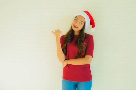 为名人戴圣诞帽的美丽的亚洲年轻女性肖像