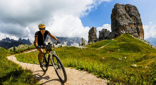 Tourist cycling in Cortina dAmpezzo, stunning Cinque Torri and 