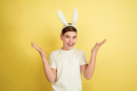 黄色画室背景上的复活节兔子男孩有着明亮的情感