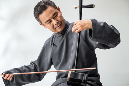 男艺术家在拉二胡照片