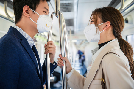 戴口罩的青年情侣乘坐地铁 照片