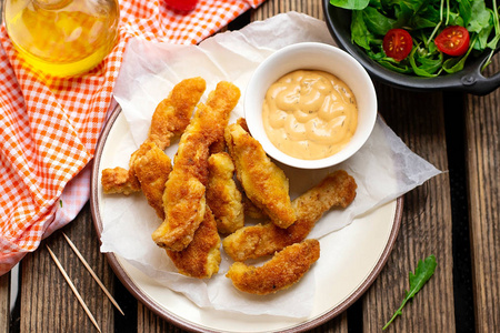 Homemade breaded chicken fingers nuggets with lettuce 