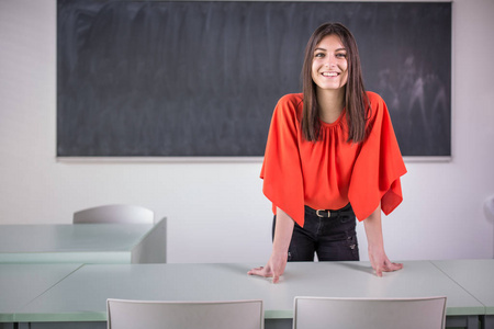 Pretty, young female teacher in front of a classroom 
