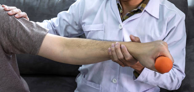 Doctor physiotherapist treating rehabilitation arm pain patient 