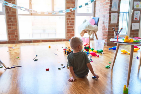 年轻的白人小孩在幼儿园玩玩具。就学前的