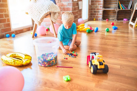 年轻的白人小孩在幼儿园玩玩具.就学前的照片
