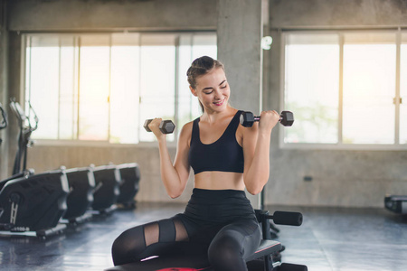 Beautiful girl caucasian is exercising with lifting dumbbell in 