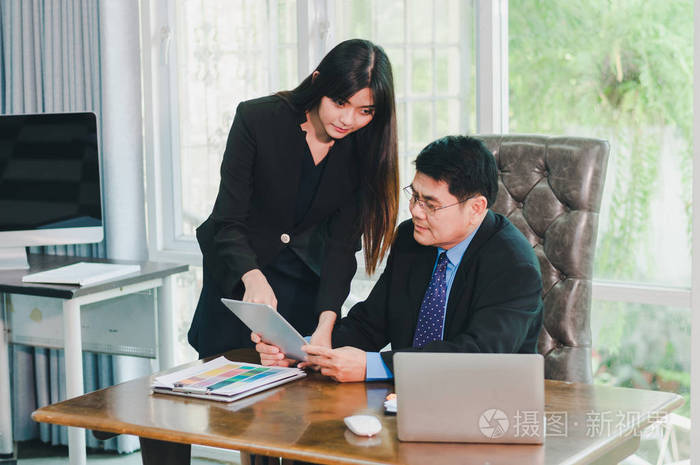 经理和秘书正在讨论办公室的工作