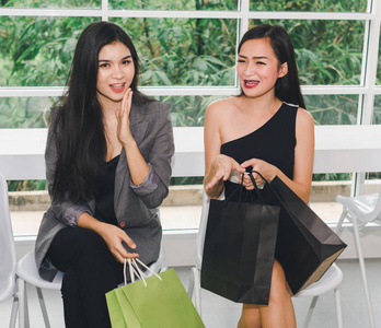 亚洲女孩的画像购物乐趣去购物。表演袋子和