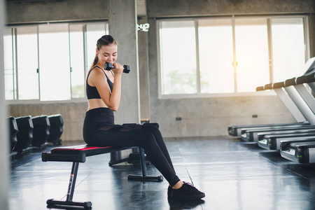 Beautiful girl caucasian is exercising with lifting dumbbell in 