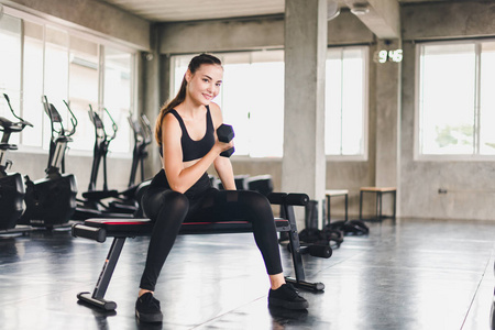 Beautiful girl caucasian is exercising with lifting dumbbell in 