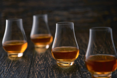 四杯威士忌，黑色背景，选择性聚焦。