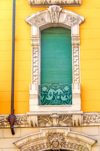 House with yellow wall. Window with green shutter. Italy. 