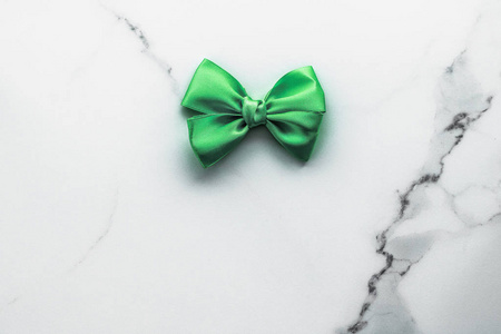 Green silk ribbon and bow on marble background, St Patricks day 