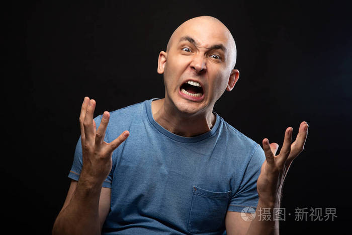 愤怒的秃头男子穿着蓝色t恤的照片