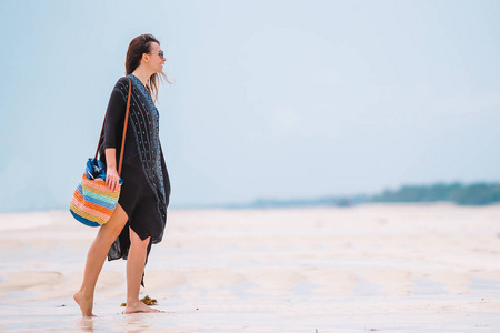 年轻漂亮的女人在热带海滨嬉戏。快乐女孩漫步在白沙热带海滩