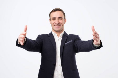 喜出望外的穿着西装的男人张开双手欢迎他的伙伴或朋友.照片