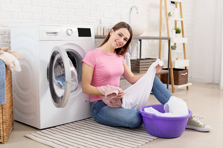 年轻的家庭主妇在家洗衣服照片