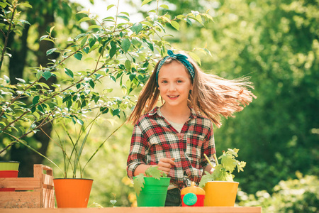 春天阳光明媚的日子里,可爱的小女孩在花园里浇花.生态生活.