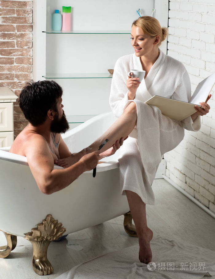 相爱的情侣在早上梳洗英俊的胡子男人在洗澡幸福的年轻夫妇在家里的