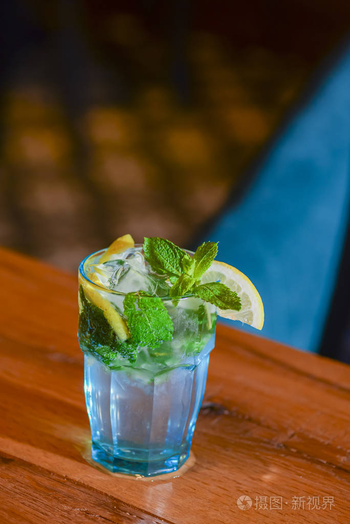 酒吧桌上的经典新鲜莫吉托酒精鸡尾酒加冰块薄荷和酸橙背景模糊
