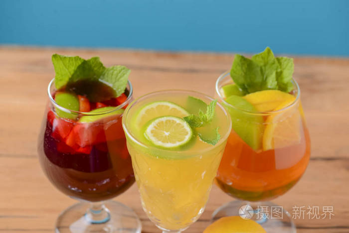 三种热带混合饮料柠檬叶薄荷叶放在乡村木桌上的不同玻璃杯里