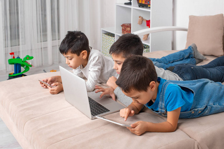 Children of different ages use gadgets for games, communication 