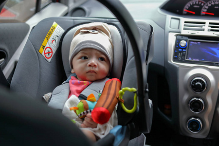 可爱的小男孩坐在汽车安全带锁保护驾车旅行