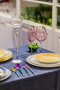 婚礼或其他活动用金粉色餐桌，酒杯盘子勺子叉子蜡烛