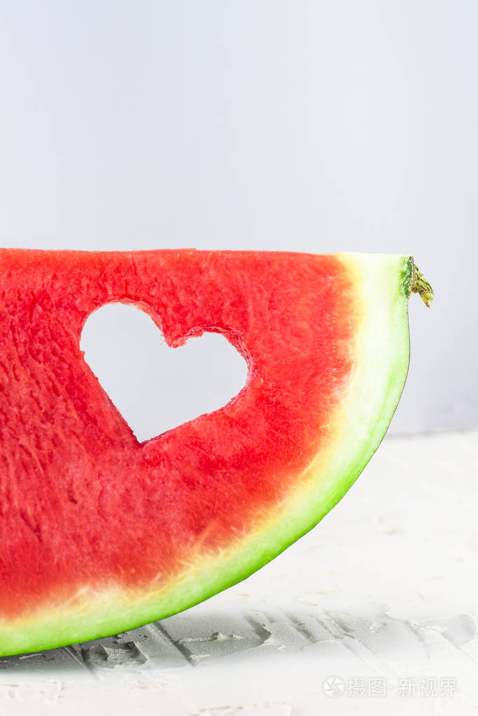 新鲜多汁西瓜片白底心形孔情人节爱情夏日概念