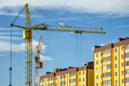 Building crane and buildings under construction against evening 