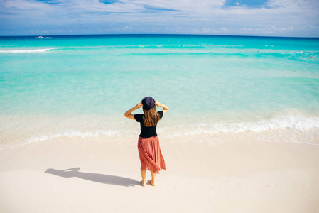 girl in a hat on a background of the ocean. Beautiful girl looks