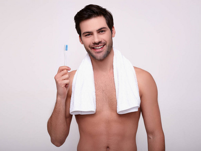 洗完澡，手里拿着牙刷微笑的男人。