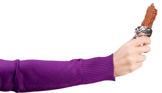 穿着鲜紫色运动衫的女性手拿着一块打开的巧克力棒。孤立的