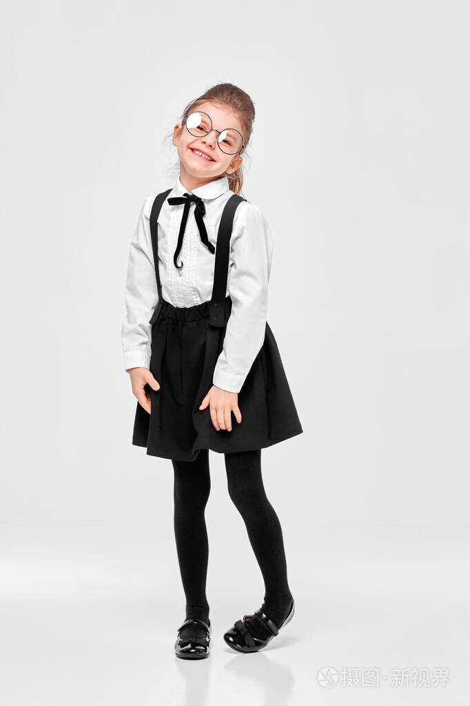 全身尺寸的漂亮可爱可爱可爱害羞的女生穿着制服戴圆眼镜孤立于灰色