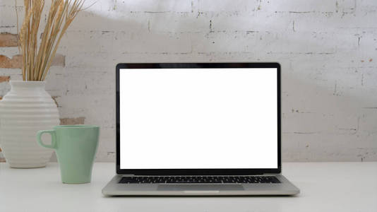 Close up view of simple workplace with mock up laptop , coffee c