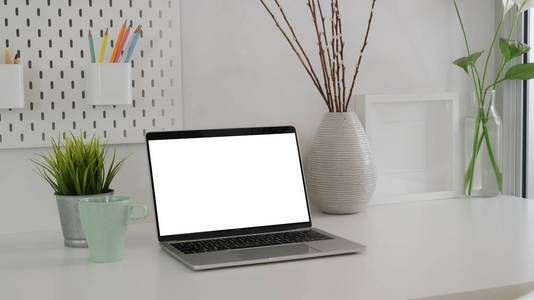 Cropped shot of minimal workspace with blank screen laptop, coff