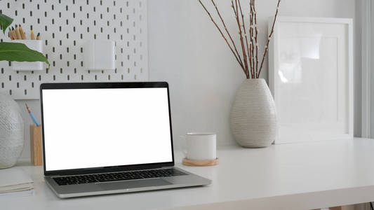 Cropped shot of modern workspace with blank screen laptop, mock 