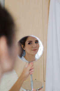 美丽的女人看着镜子里的自己。
