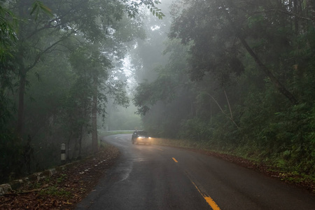 雾蒙蒙的山路，背景是一辆汽车。