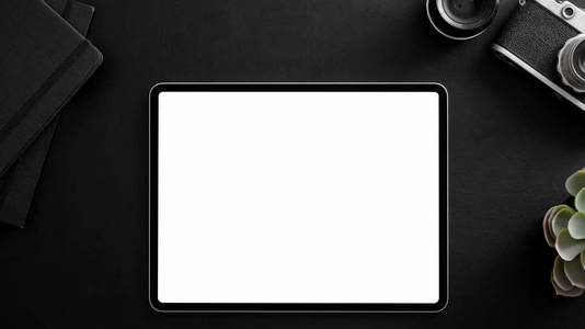 Top view of photographer workplace with blank screen tablet, cam