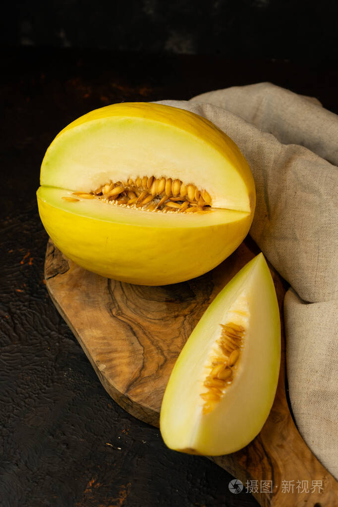 深色背景下多汁的黄色甜瓜