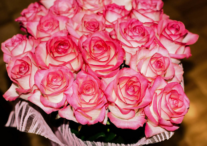 木质背景上有精致芳香的玫瑰花，是节日礼物