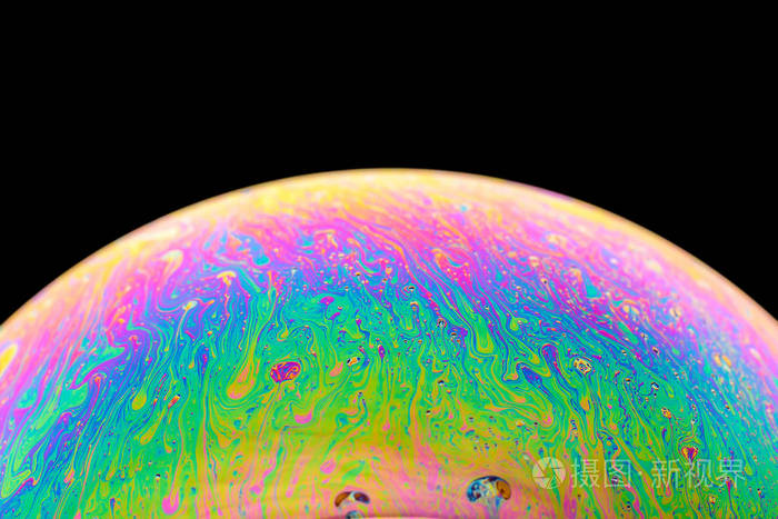 彩虹肥皂泡在孤立的黑色背景上彩色表面的特写镜头海报空白