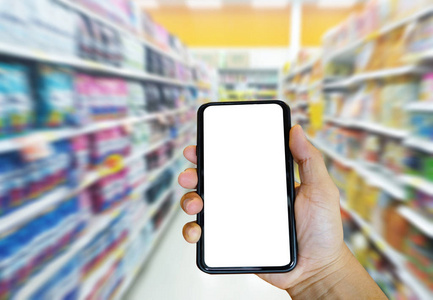 手持式智能手机购物网上超市与模糊超市背景。电子商务和技术概念。