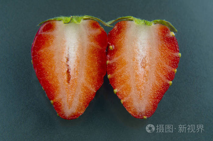 半个草莓在绿色的背景上