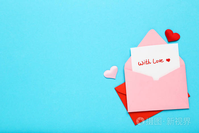 蓝色背景上有爱心的纸信封和带有爱的文字