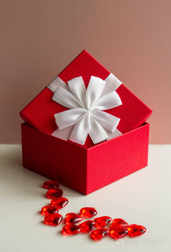打开带有白色蝴蝶结的红色礼盒爱的礼物概念