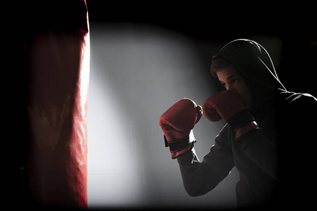 The young man workout a kick on the punching bag 