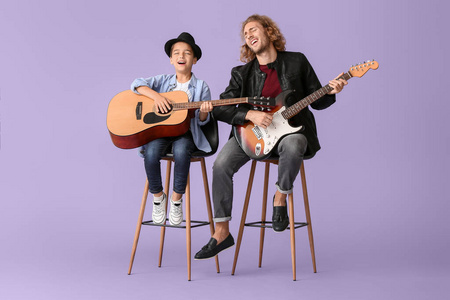 男人和他的小儿子在彩色背景上弹吉他